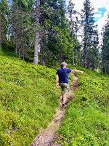 a man walking on a trail in the woods at Chalet Cosy in Bramberg am Wildkogel