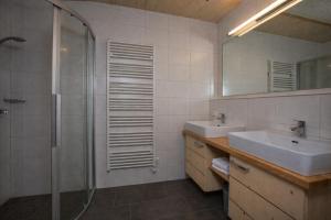 a bathroom with a shower and a sink and a mirror at Chalet Cosy in Bramberg am Wildkogel