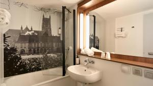 a bathroom with a sink and a mirror at Campanile NATURE - Meaux in Meaux