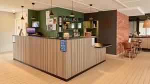 a bar in a restaurant with a counter at Campanile NATURE - Meaux in Meaux