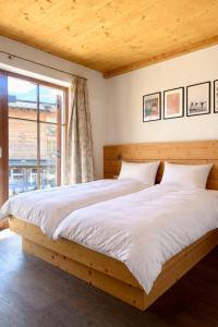 a large bed in a room with a large window at Chalet Cosy in Bramberg am Wildkogel