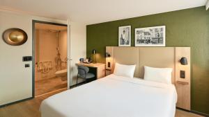 a hotel room with a bed and a bathroom at Campanile NATURE - Meaux in Meaux +25 photos