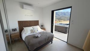a bedroom with a bed with a view of a tub at villa la baies des anges in Calcatoggio +28 photos