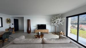 a living room with a couch and a tv at villa la baies des anges in Calcatoggio