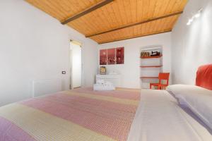 a bedroom with a large bed and a wooden ceiling at Prima Del Cielo - Alba Apartment in Perledo