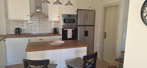a kitchen with a refrigerator and a counter with chairs at Lilli's House in Kassiopi