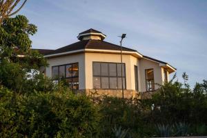 a house on top of a hill with trees at Lusoi Gardens Naromoru in Nyeri