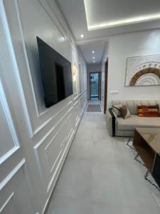 a living room with a couch and a tv on a wall at Appartement suite in Cabo Negro