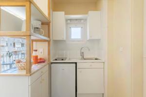 a kitchen with white cabinets and a sink at Résidences LES HAUTES PLAINES in Gréoux-les-Bains