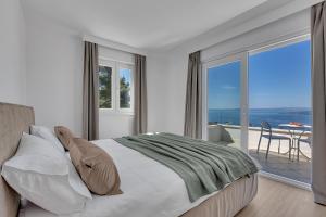 a bedroom with a bed with a view of the ocean at Villa Prestige in Baška Voda +171 photos