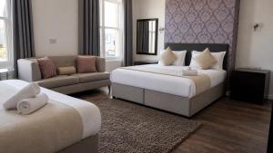 a hotel room with two beds and a couch at Park Hotel & Apartments in Hull +24 photos