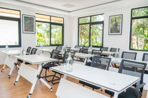a classroom with tables and chairs and windows at Lusoi Gardens Naromoru in Nyeri