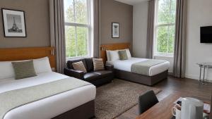 a hotel room with two beds and a chair at Park Hotel & Apartments in Hull