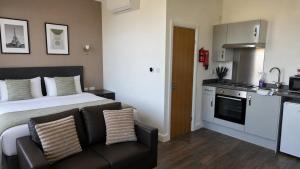 a bedroom with a bed and a couch and a kitchen at Park Hotel & Apartments in Hull