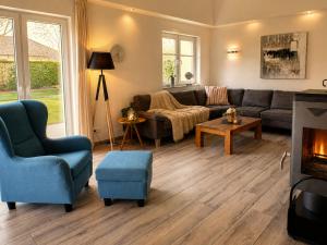 a living room with a couch and chairs and a fireplace at Reetdachhaus 5, inkl 2 Parkplätze in Fehmarn