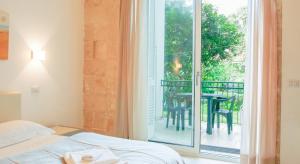 a bedroom with a bed and a balcony with a table at La Bella Lecce Apartment in Lecce