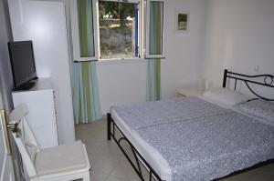 a bedroom with a bed and a tv and a window at Villa Pilias Methoni in Methoni