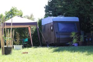 an rv parked in the grass next to a tent at La caravane plage in Pietroso +6 photos