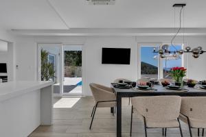 a kitchen and dining room with a table and chairs at Villa Prestige in Baška Voda