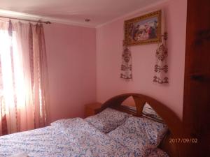 a bedroom with a bed and a picture on the wall at Котедж - Prestige in Vorokhta
