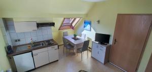 a small kitchen with a table and a small kitchen with a sink at Ferienwohnung Stechlin, Neuglobsow in Stechlin