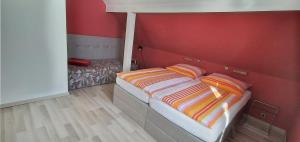 a bedroom with a bed with a red wall at Ferienwohnung Stechlin, Neuglobsow in Stechlin