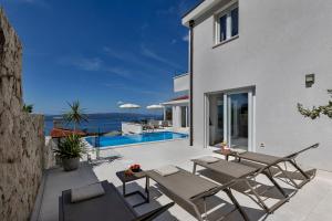 a house with a patio with a view of the ocean at Villa Prestige in Baška Voda