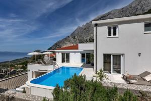 a villa with a swimming pool and a house at Villa Prestige in Baška Voda
