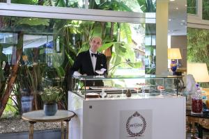 a man in a tuxedo standing behind a counter at Grand Hotel Del Mare Resort & Spa in Bordighera +242 photos