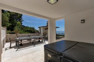 a kitchen with a table and a bench on a patio at Villa Prestige in Baška Voda