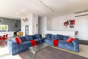 a blue couch with red pillows in a living room at Hôtel à la maison - Panache, spa et fleuve in Baie-Saint-Paul