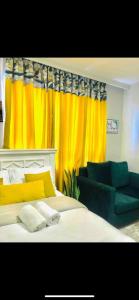 a bedroom with a bed and a yellow curtain at Airport Studio Gym pool fast WIFI Ideal for digital nomads Syokimau in Syokimau +19 photos