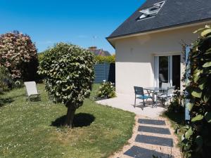 a house with a table and chairs in the yard at Gite Paul Sallou in Perros-Guirec