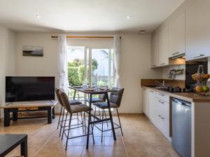 a kitchen with a table and chairs and a kitchen with a window at Gite Paul Sallou in Perros-Guirec