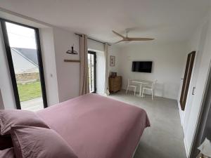 a bedroom with a pink bed and a living room at Chambre d'hôtes Lilas in Saint-Lyphard