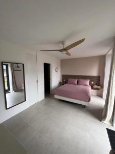a bedroom with a pink bed and a mirror at Chambre d'hôtes Lilas in Saint-Lyphard
