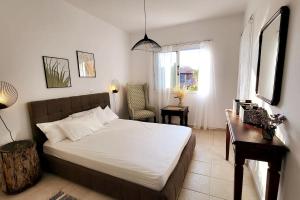 a bedroom with a bed and a desk and a window at Mandria Gardens Paradise II in Mandria +22 photos