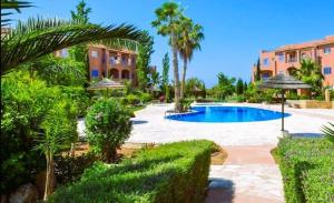 a resort with a swimming pool and palm trees at Mandria Gardens Paradise II in Mandria
