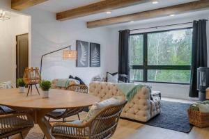 a living room with a table and a couch at Hôtel à la maison - Le Rendez-vous ! in Magog-Orford