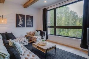 a living room with a couch and a large window at Hôtel à la maison - Le Rendez-vous ! in Magog-Orford