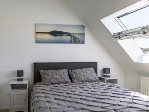 a bedroom with a bed and two windows at Gite Paul Sallou in Perros-Guirec