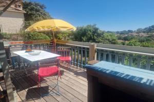 a deck with a table and a yellow umbrella at Maison Diana in Vence