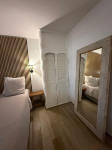 a mirror in a bedroom with a bed and a mirror at Ti Kaz Paradise in Le Diamant +16 photos