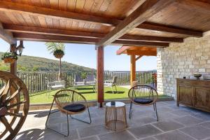 two chairs and a table on a patio with a view at Villa Luisana con Piscina e Vista in Sonnino