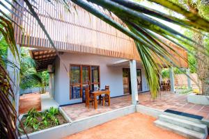 a house with a table and chairs in front of it at Viento - Habarana in Habarana