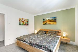 a bedroom with a bed and two paintings on the wall at Apartment Burgquartier in Schmallenberg