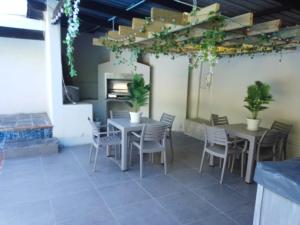 a patio with two tables and chairs and plants at Nolangeni Lodge in Margate