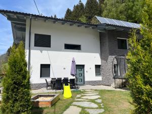 a white and black house with a yellow object in the yard at Ferienappartement Sieger in Großkirchheim +8 photos