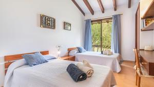 two beds in a room with a window at Sa Font den Ros Mallorca in Son Servera +25 photos