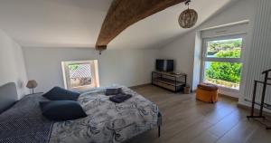 a bedroom with a bed and a television and a window at Chez Pauline - Chambres d'hôtes Bourguignonnes in Prissé +5 photos